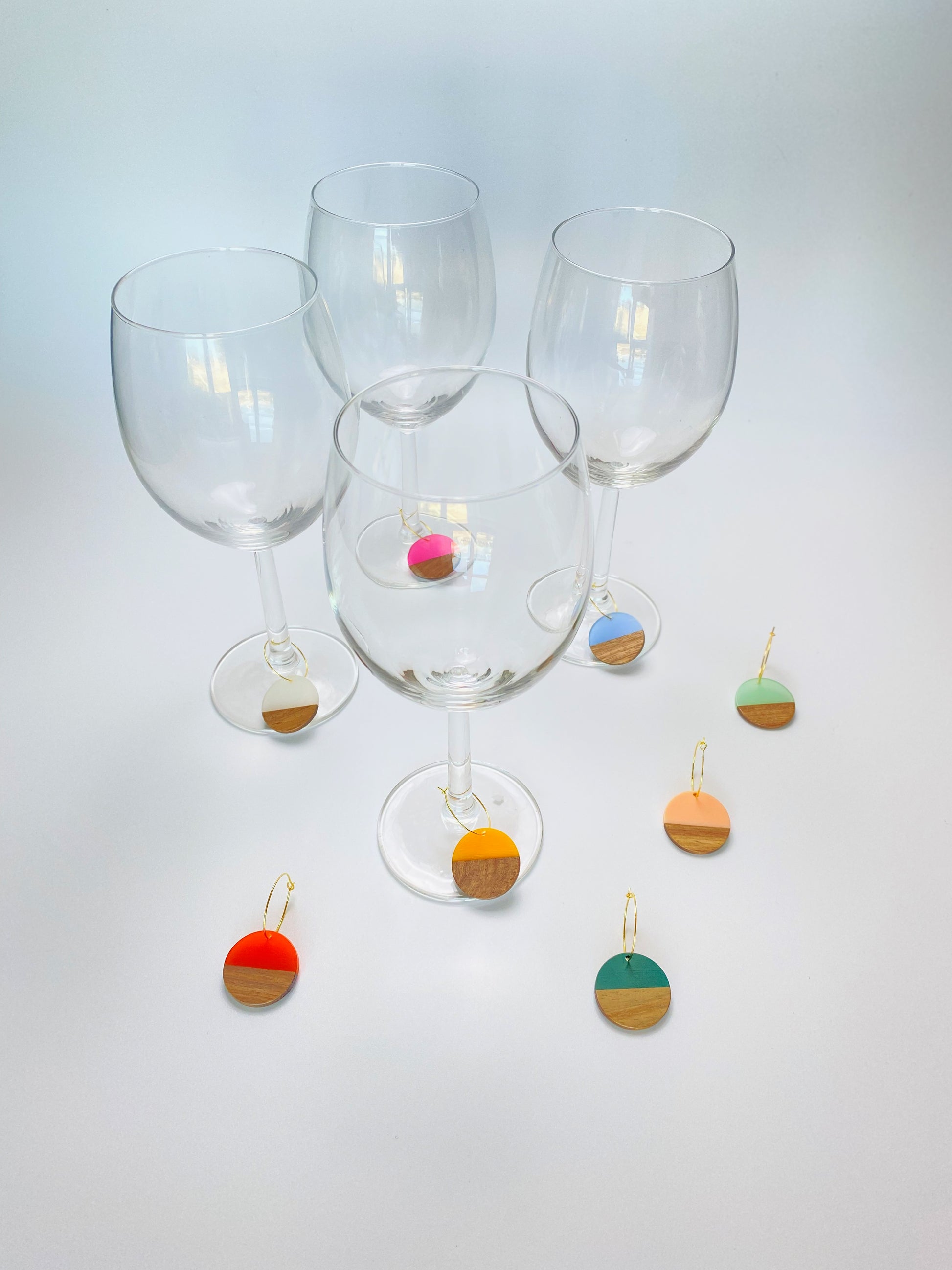 Colorful resin wood circle discs on gold wine charm rings