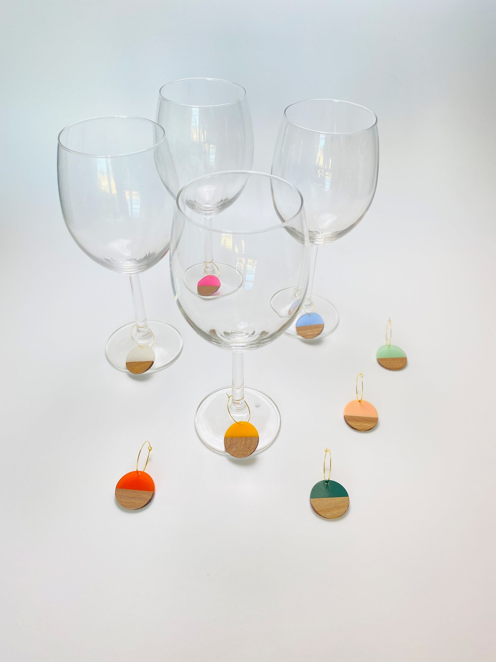 Colorful resin wood circle discs on gold wine charm rings