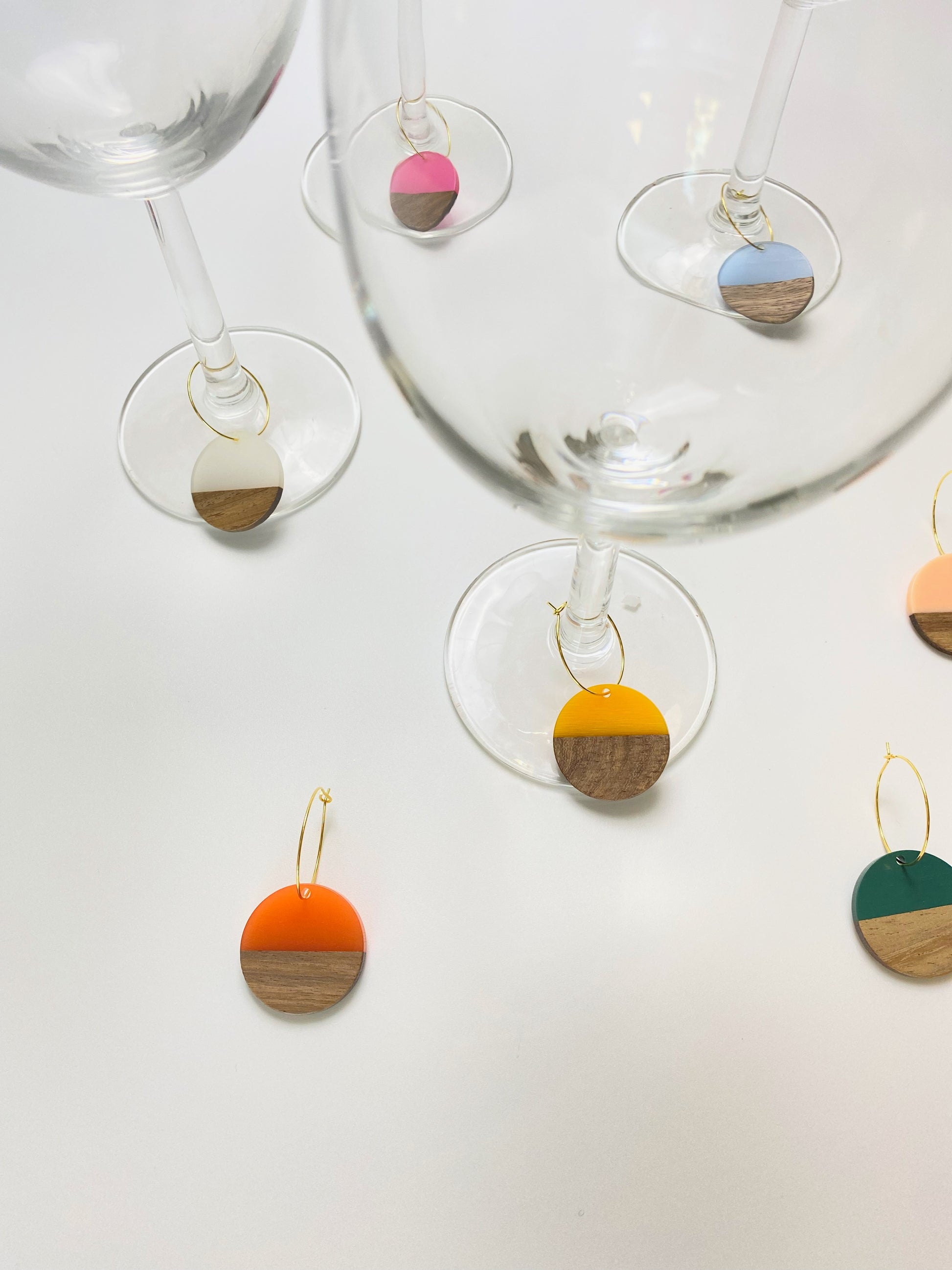 Colorful resin wood circle discs on gold wine charm rings