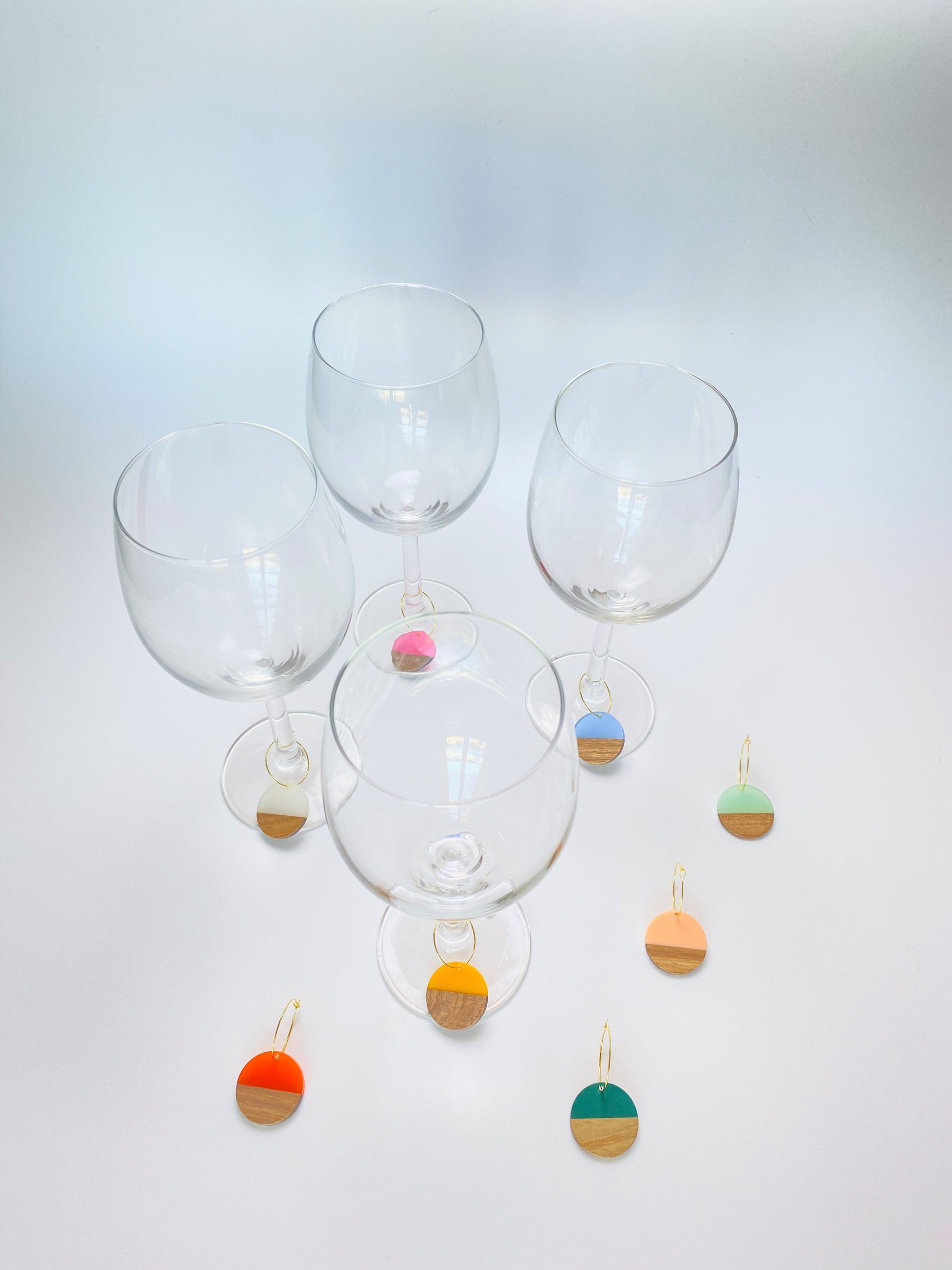 Colorful resin wood circle discs on gold wine charm rings