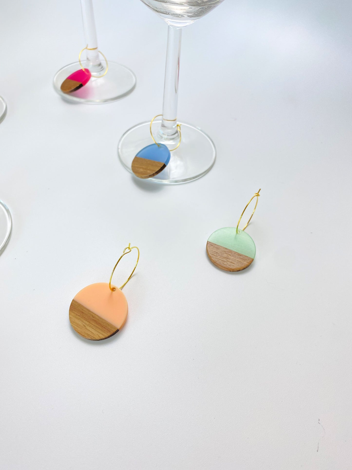 Colorful resin wood circle discs on gold wine charm rings