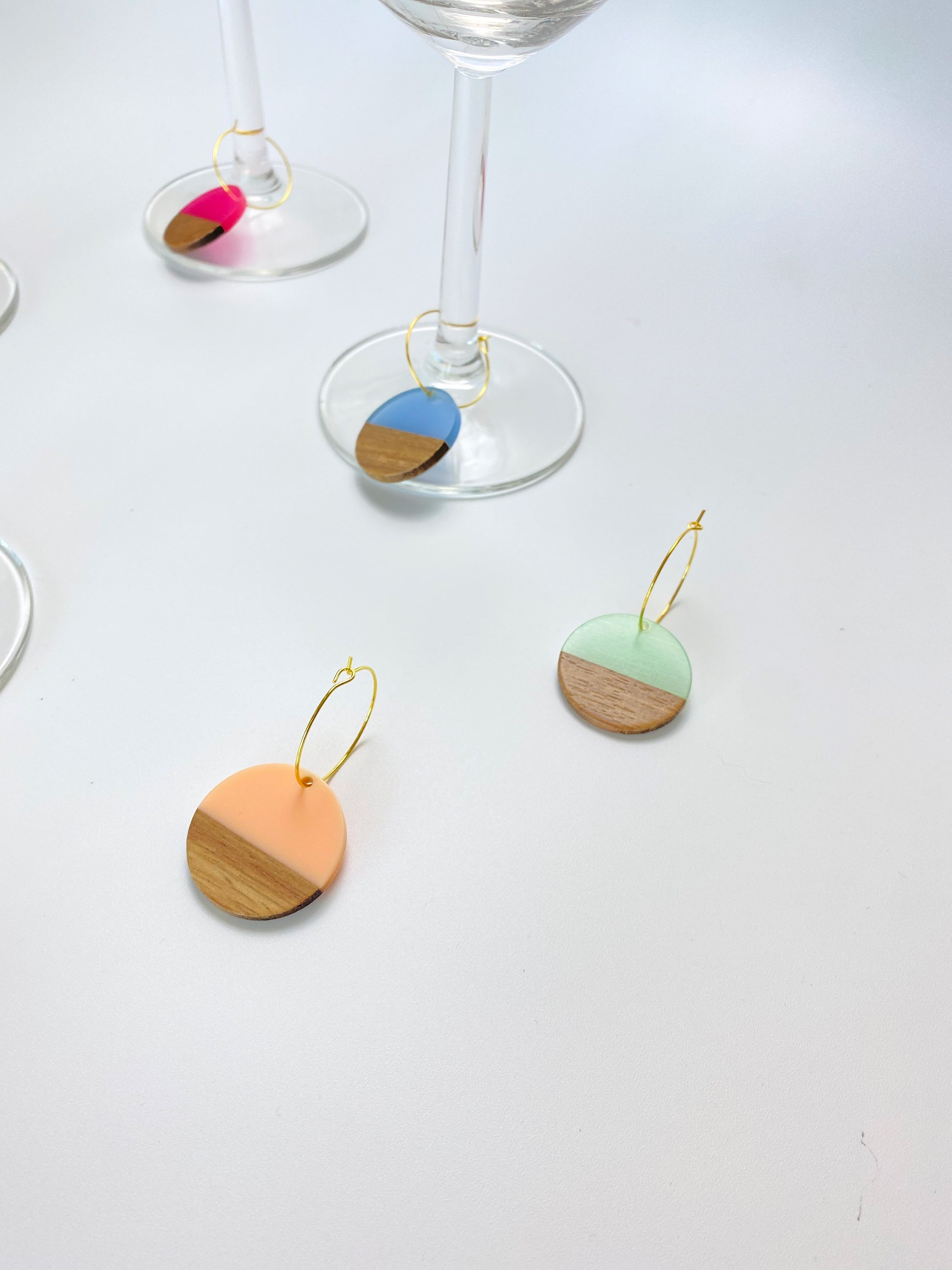 Colorful resin wood circle discs on gold wine charm rings